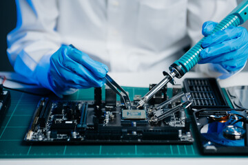 The technician is putting the CPU on the socket of the computer motherboard. electronic engineering...