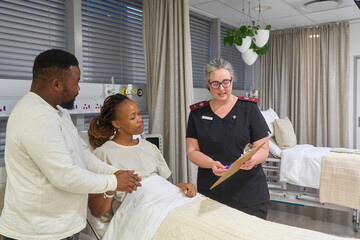 young couple discuss results with nurse in hospital