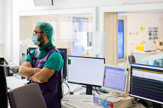 Electrophysiologist in uniform standing near computers