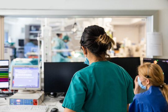 Woman doctors in uniform gathered near desktop monitor