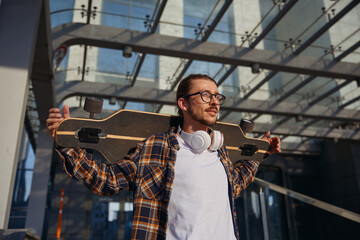 Portrait of young cool hipster man enjoying skateboarding hobby
