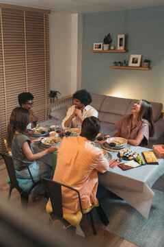 Diverse Friends Having Dinner at home While chatting