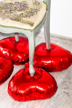 antique classic chair stands on balloons in the shape of a heart