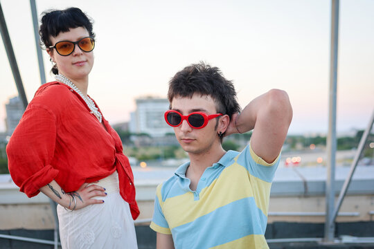 Alternative and stylish couple wearing colorful clothes and sunglasses