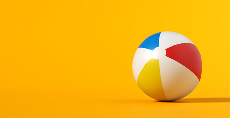 Inflatable beach ball on yellow summer background.