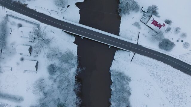 Snow-covered landscape with bridge over Abava river near Renda village (Kuldiga parish, Latvia), aerial birdseye view