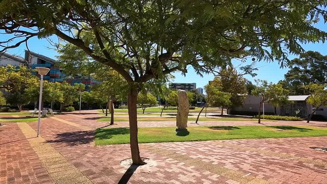 Walking under the trees and landscaped exterior of buildings on sunny day