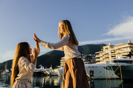 Naklejki Sisters playing patties on the yacht pier