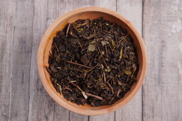 green tea leaves on wooden bowl on wooden table