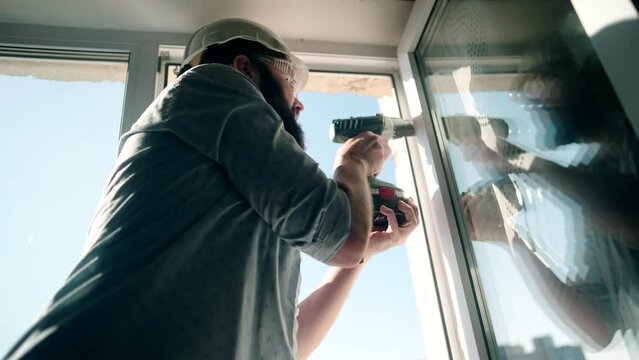 Worker replacing an old window with new plastic window . Apartment renovation	