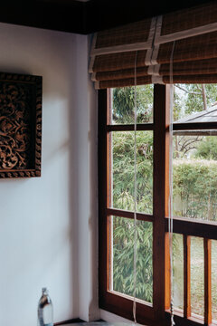 Lush tropical foliage viewed through a teak framed window