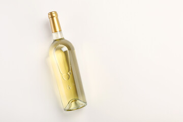Bottle of expensive white wine on light background, top view. Space for text
