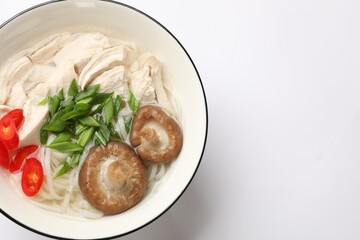 Delicious ramen with meat and mushrooms in bowl on white background, top view. Space for text