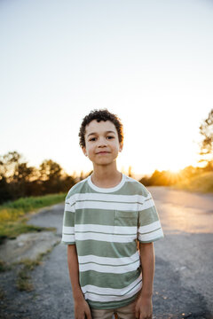Portrait of cute curly haired boy having fun outside.