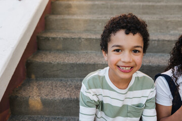 Portrait of cute curly haired boy having fun outside.