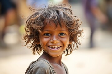 Dalit child, around 5-6 years old, engaged in play. The child's clothing is simple, possibly hand-me-downs, yet the joy and innocence in their eyes reflect the universal spirit of child - obrazy, fototapety, plakaty