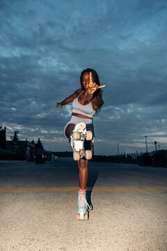 Cheerful black woman rollerblading and having fun