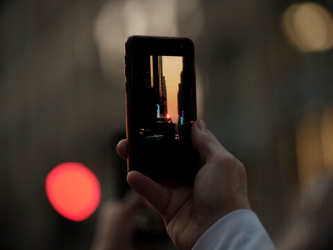 Manhattan henge hand holding a phone