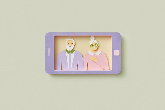 Paper smartphone showing image of senior couple.