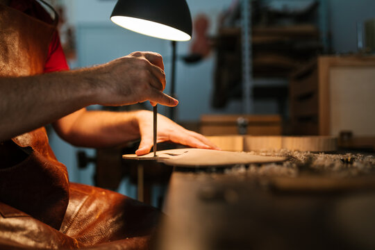 Male luthier creating design for violin