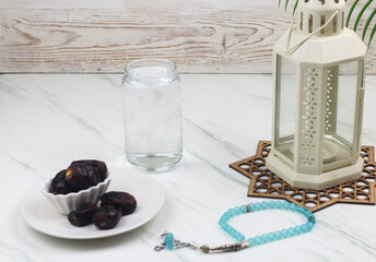 Kurma dan Air Putih, Dates fruit and water on marble white background. Breakfasting concept in Ramadan month. Islamic template for text background. 