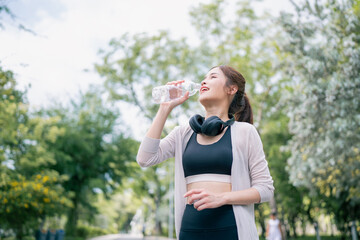 Portrait of young woman in fitness wear exercising in park. Healthy Concept, copy space.