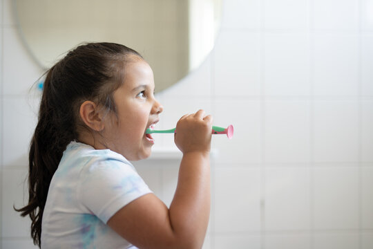 Girl with her mouth wide open brushing her teeth