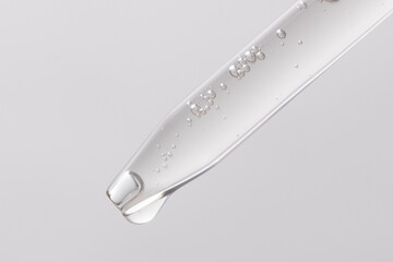 macro image of clear serum dripping out of dropper
