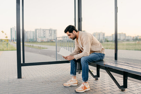 A man reads a book at a bus station