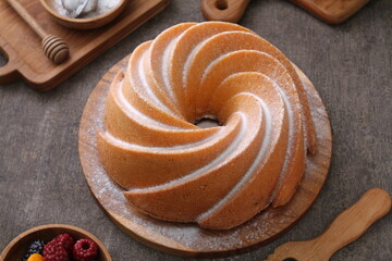 A very delicious and tempting cake served with powdered sugar and fruit