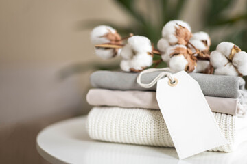 A neat stack of clean knitwear in neutral colors. Concept for sale, recycling and storage of...