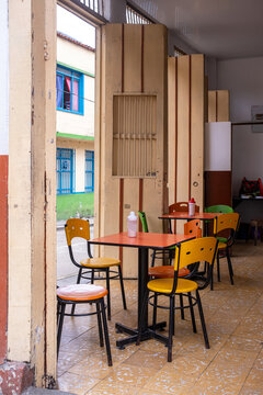 Interior of colombian coffee shop with doors tables chairs in daylight