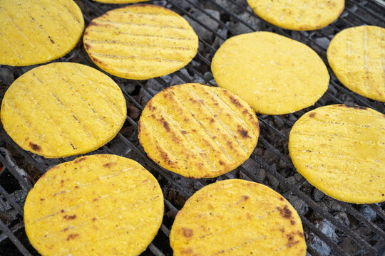 Yellow corn arepas on grille