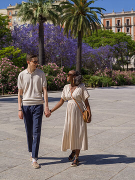 Happy diverse couple strolling on city square