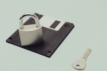 The lock with key is on the black retro 3.5" floppy diskette. Cyber security and data protection concept. 90s technology.