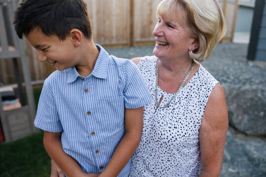 Portraits of young boy and his grandma being playful together ou