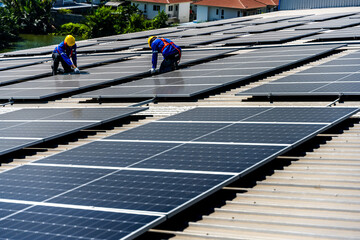 Two solar roof engineer men working on height installing solar panels on factory building roof