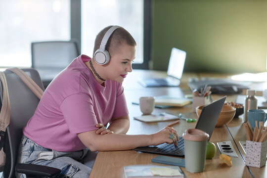 Gen Z Woman In Headphones At Work In Office