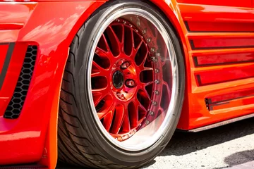 Deurstickers Red Sports Tuned Car Rear View Wheel Close Up Fashion Car Day Road © Raima