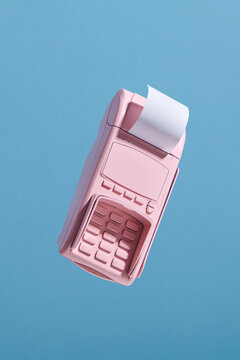 Payment terminal with cash tape on pink background