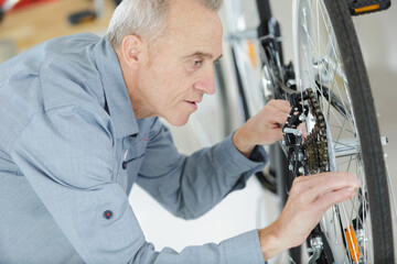 older man repairing a bicycle