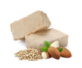 Tasty halva, peeled sunflower seeds, almonds and green leaves isolated on white