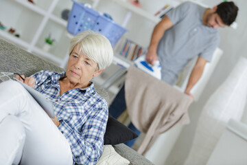 Obraz premium senior reading book on the sofa carer ironing