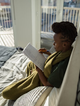 Focused black woman learning language in apartment