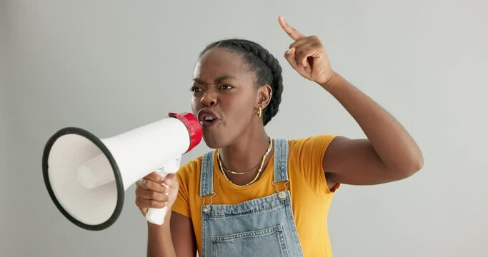 Megaphone, angry or black woman shouting in studio on grey background for change rally. Screaming, news announcement or African person with loudspeaker protesting for human rights speech or justice