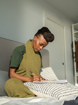 Focused female linguist writing notes in notepad