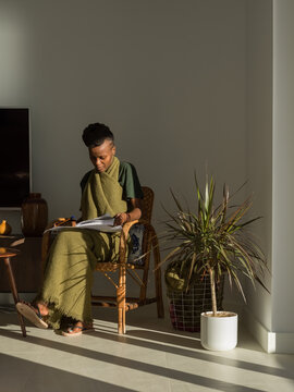 Focused woman sitting on chair and learning language