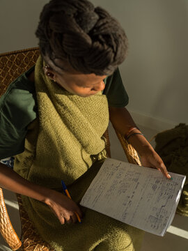 Black woman reading notes in living room
