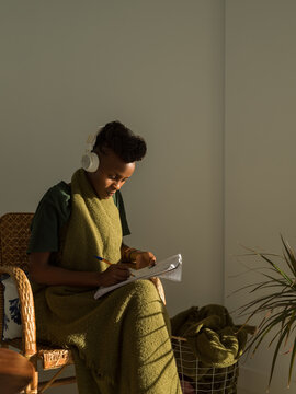 Concentrated woman taking notes during listening task