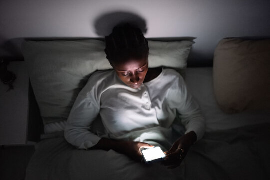 Woman messaging on smartphone late at night